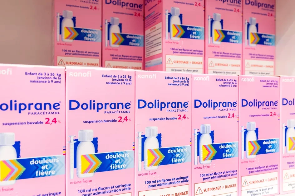 Flacon de Doliprane buvable sur fond blanc, avec étiquette et mention de rappel pour défaut de fabrication