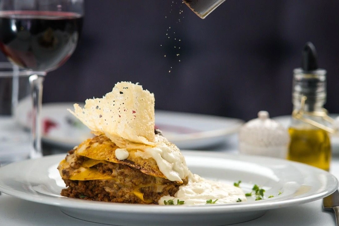 Paris : serveur apportant des assiettes dans un restaurant, logo TheFork visible sur une table