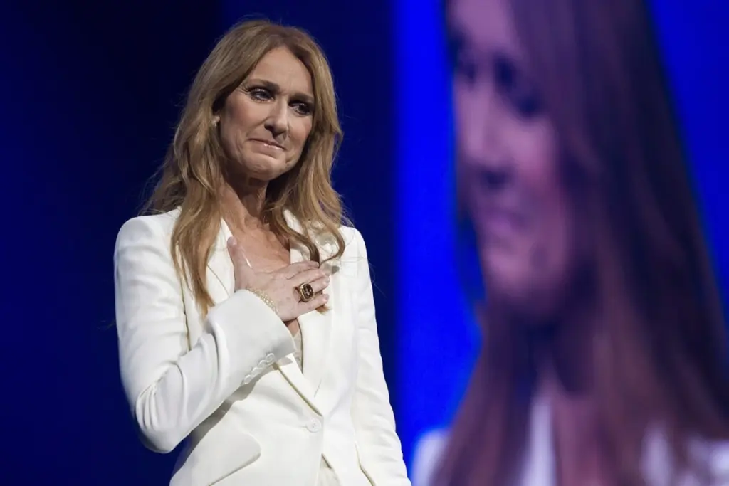 Affiche de concert à Paris mentionnant Céline Dion, collée sur un mur, avec passants en arrière-plan
