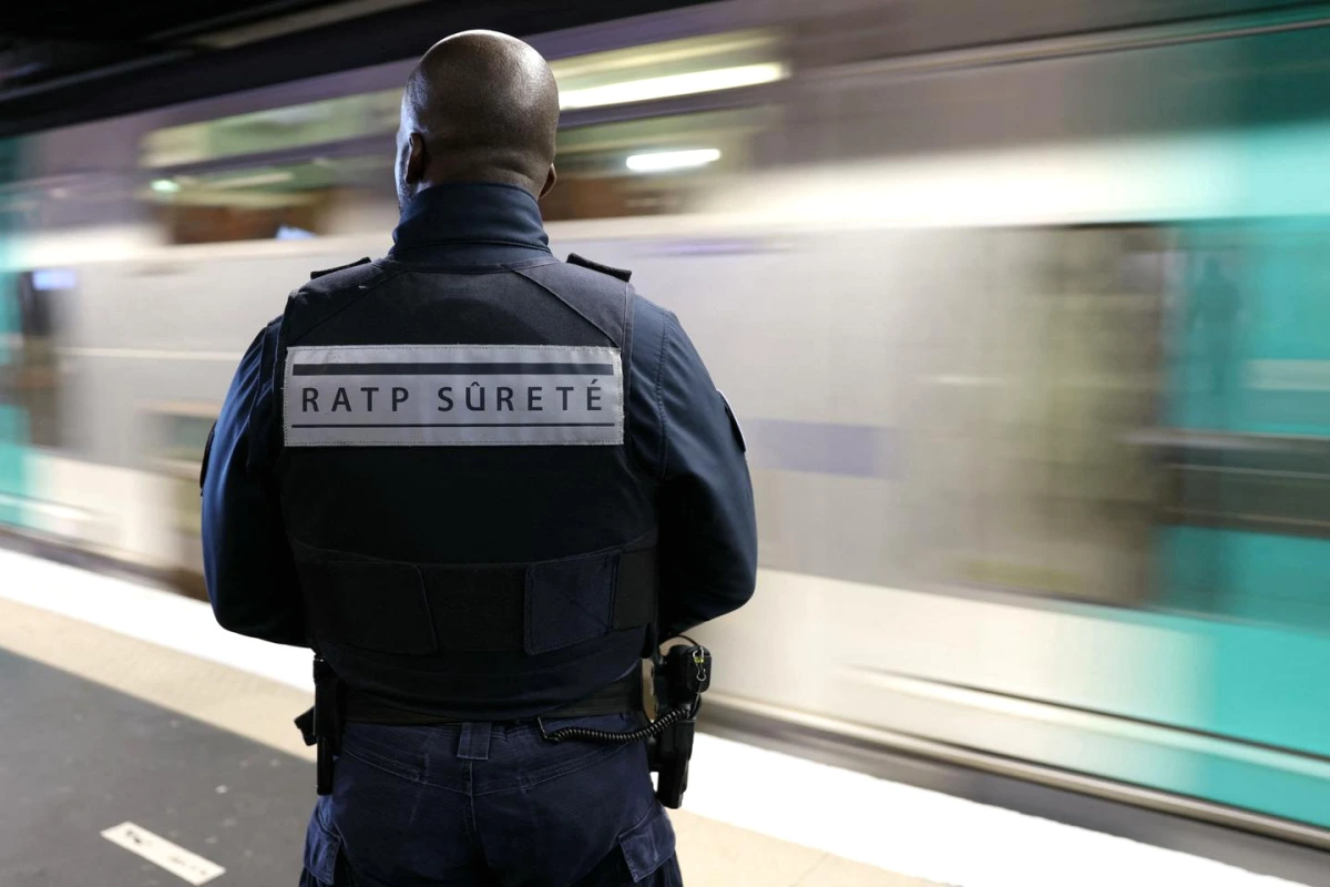 Agent de sûreté dans les transports en commun contrôlant des passagers sur un quai de métro.