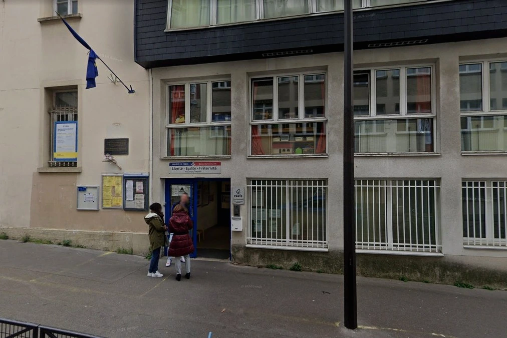 Animateur périscolaire suspendu, silhouette floutée devant une école maternelle, ruban de police en avant-plan