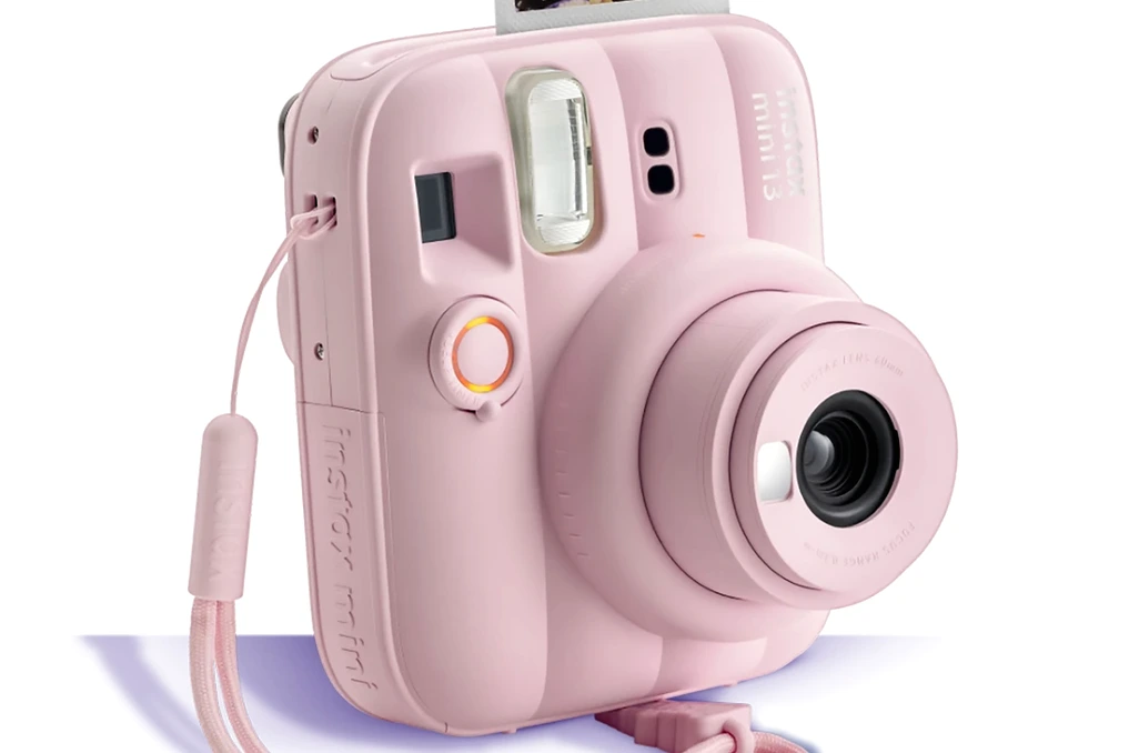 Appareil photo instantané Fujifilm Instax Mini 13 en gros plan, posé sur une surface claire, vue de face.