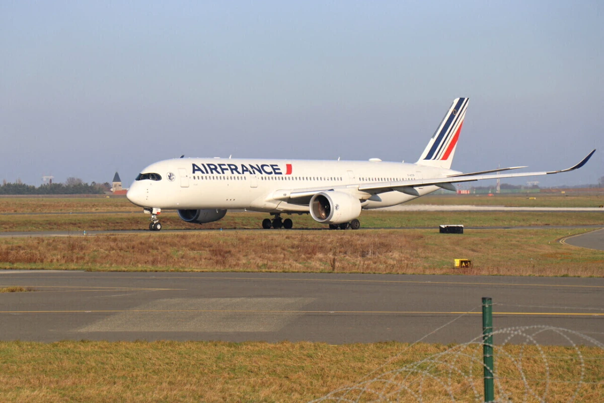 Avion Air France sur le tarmac, avec Paris en arrière-plan et panneaux d’affichage des vols annulés