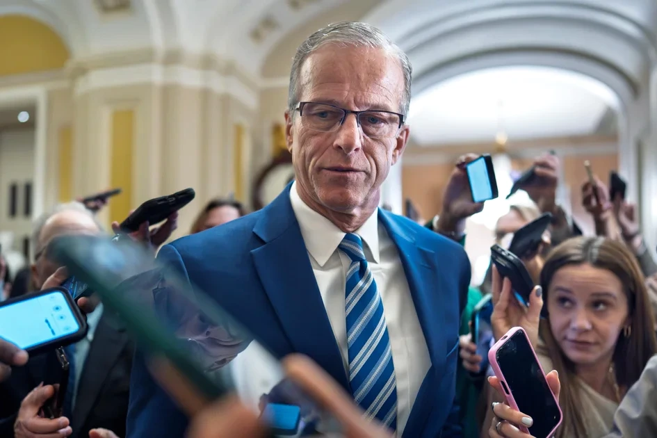 Bâtiment du DHS à Washington, drapeaux américains devant l’entrée, ciel gris en arrière-plan