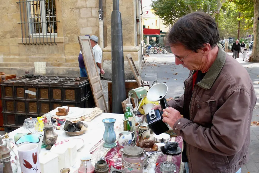 Brocante à Paris : stands de vide-grenier en plein air, passants et objets vintage sur tables