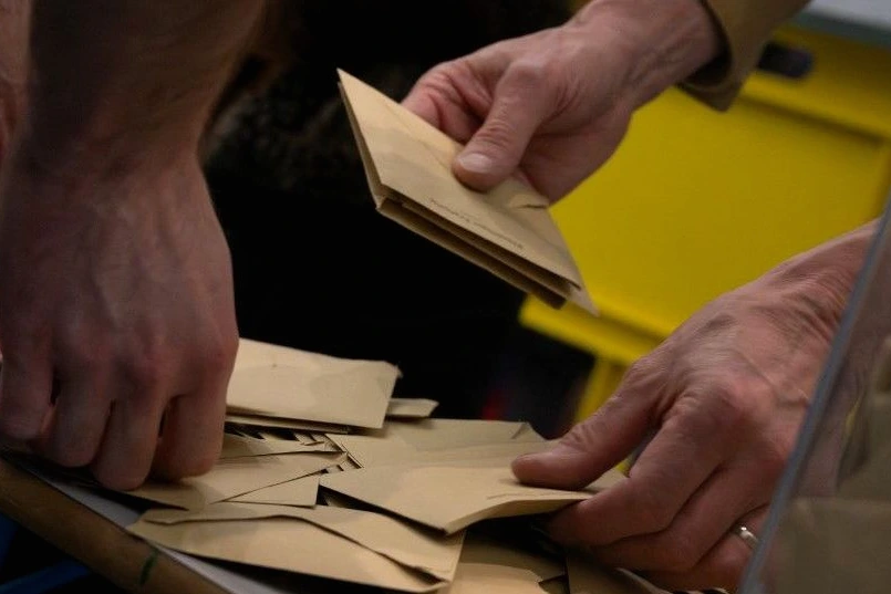 Bulletins de vote et enveloppes sur une table, avec le titre « Municipales : 3 enseignements du 1er tour »
