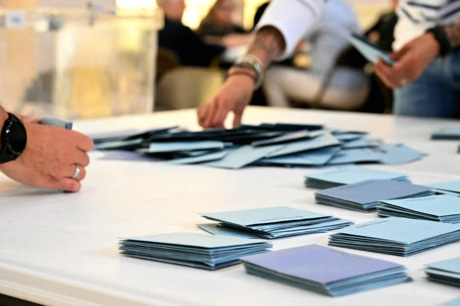 Bulletins de vote et urne transparente avec Paris, Lyon et Marseille indiqués sur une carte de France