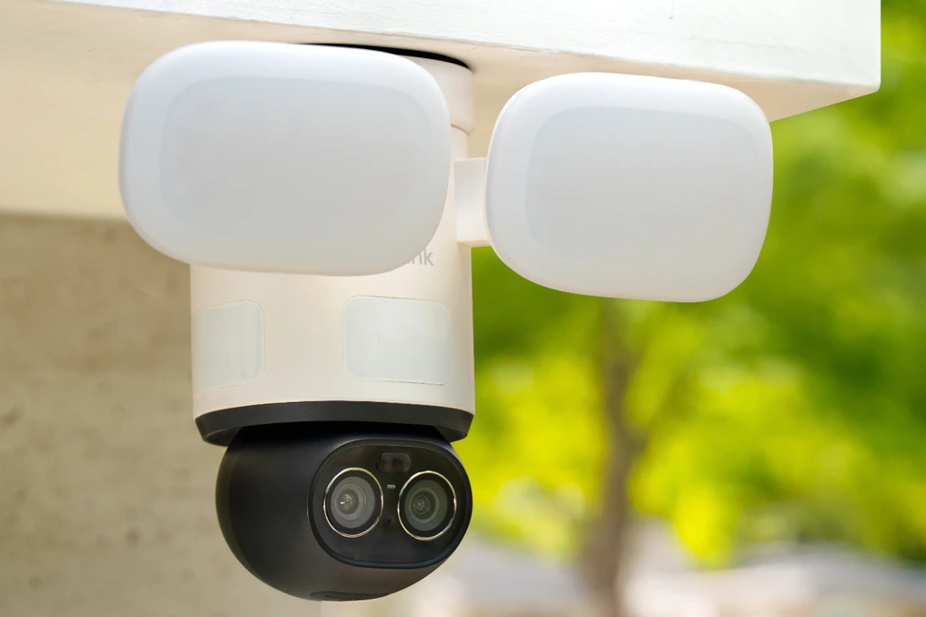 Caméra Reolink Trackflex Floodlight WiFi avec projecteurs, fixée au mur, vue en gros plan sur fond clair