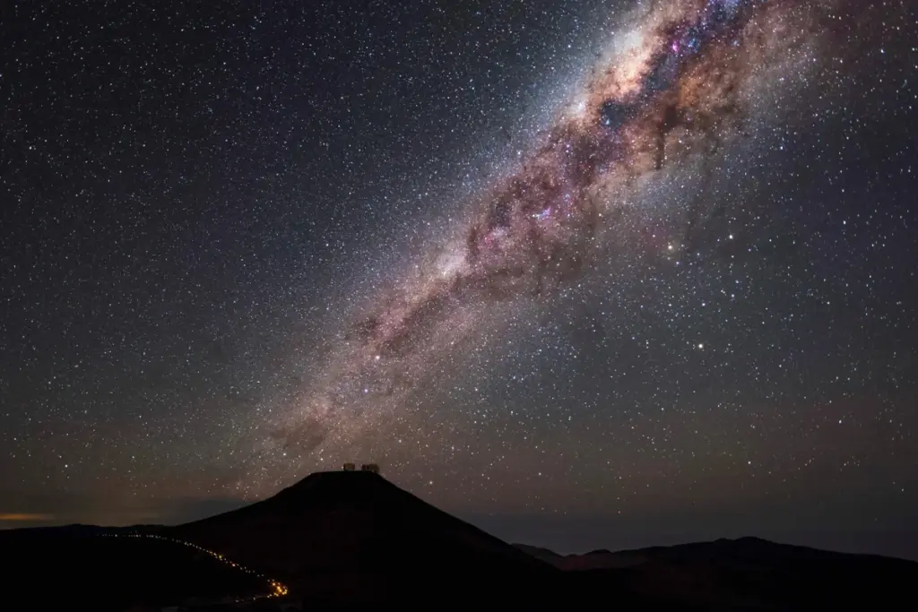 Ciel nocturne étoilé au-dessus d’une ville éclairée, les étoiles visibles malgré la pollution lumineuse