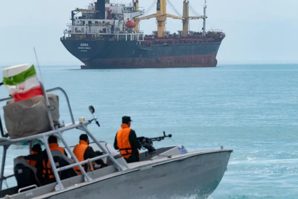 Donald Trump au pupitre lors d’une conférence de presse, drapeaux américains en arrière-plan