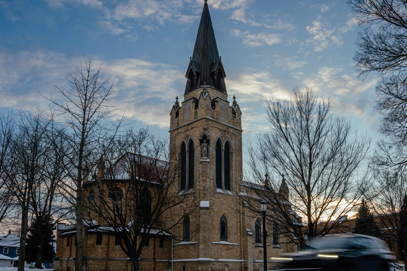 Drapeau du Minnesota flottant devant un bâtiment officiel, avec un panneau d’entrée au premier plan