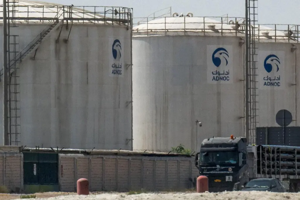 Drapeau iranien flottant devant un bâtiment officiel, avec un drapeau du Canada en arrière-plan