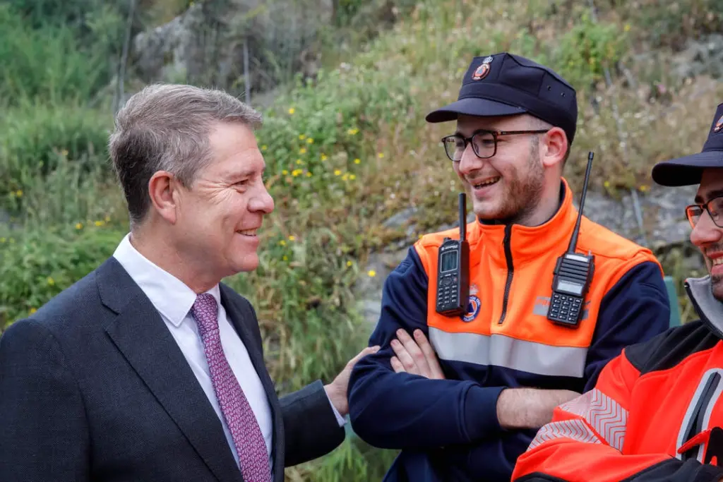 Emiliano García-Page en costume, parlant devant des drapeaux, lors d’une conférence de presse.