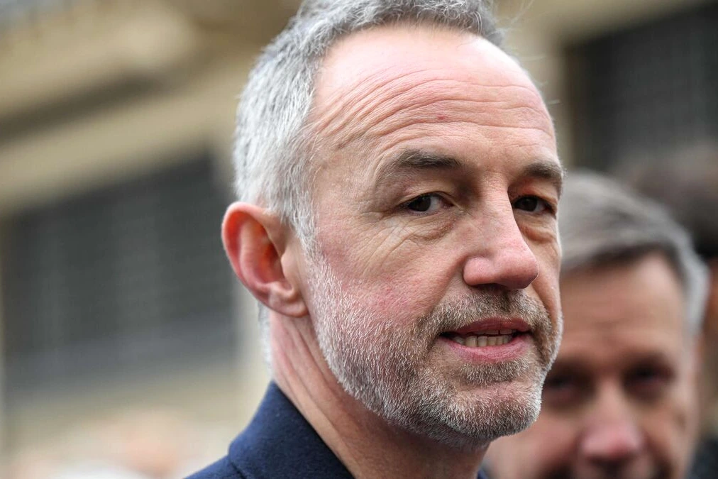 Emmanuel Grégoire s’exprime devant des micros à Paris, avec la mairie en arrière-plan.