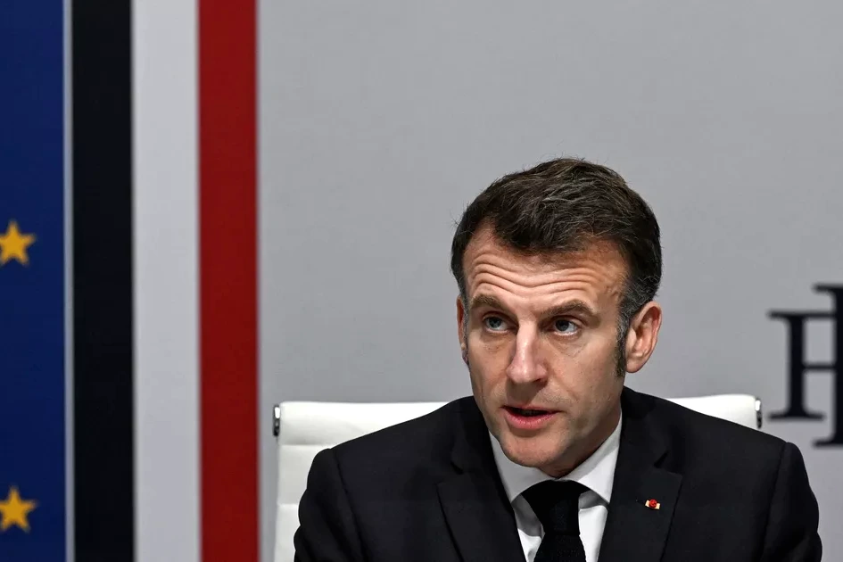 Emmanuel Macron s’exprime au pupitre lors d’un discours, drapeaux français et européen en arrière-plan