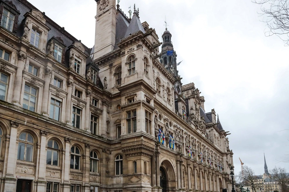 Façade de l’Hôtel de Ville de Paris, drapeaux français et européen flottant au-dessus de l’entrée