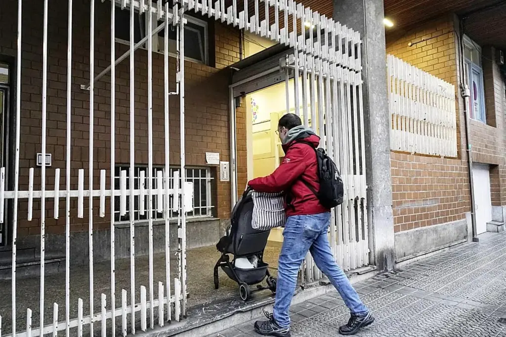 Façade d’une crèche à Getxo, entrée fermée avec ruban de police, poussettes et panneaux d’avertissement visibles