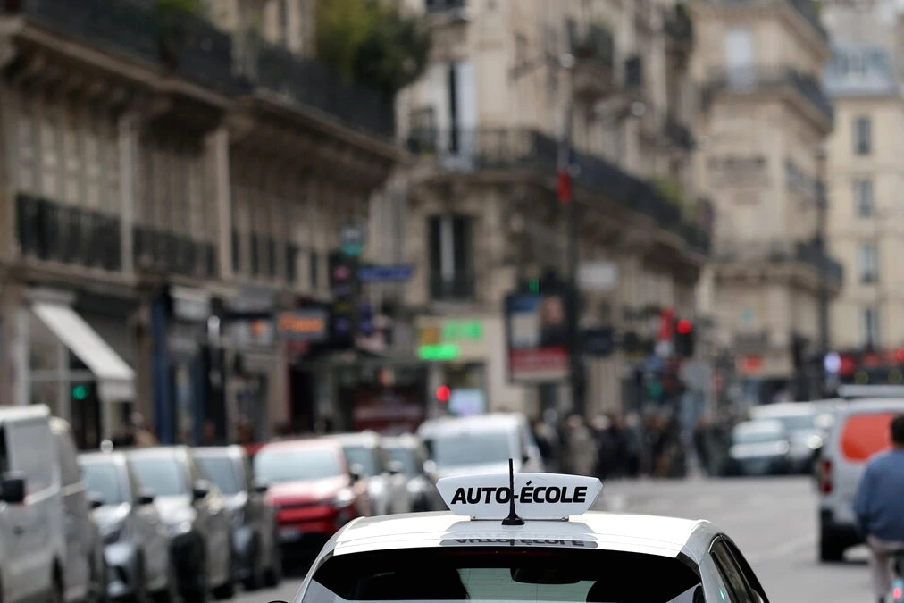 Homme fumant un joint dans une rue la nuit, gyrophares de police flous en arrière-plan