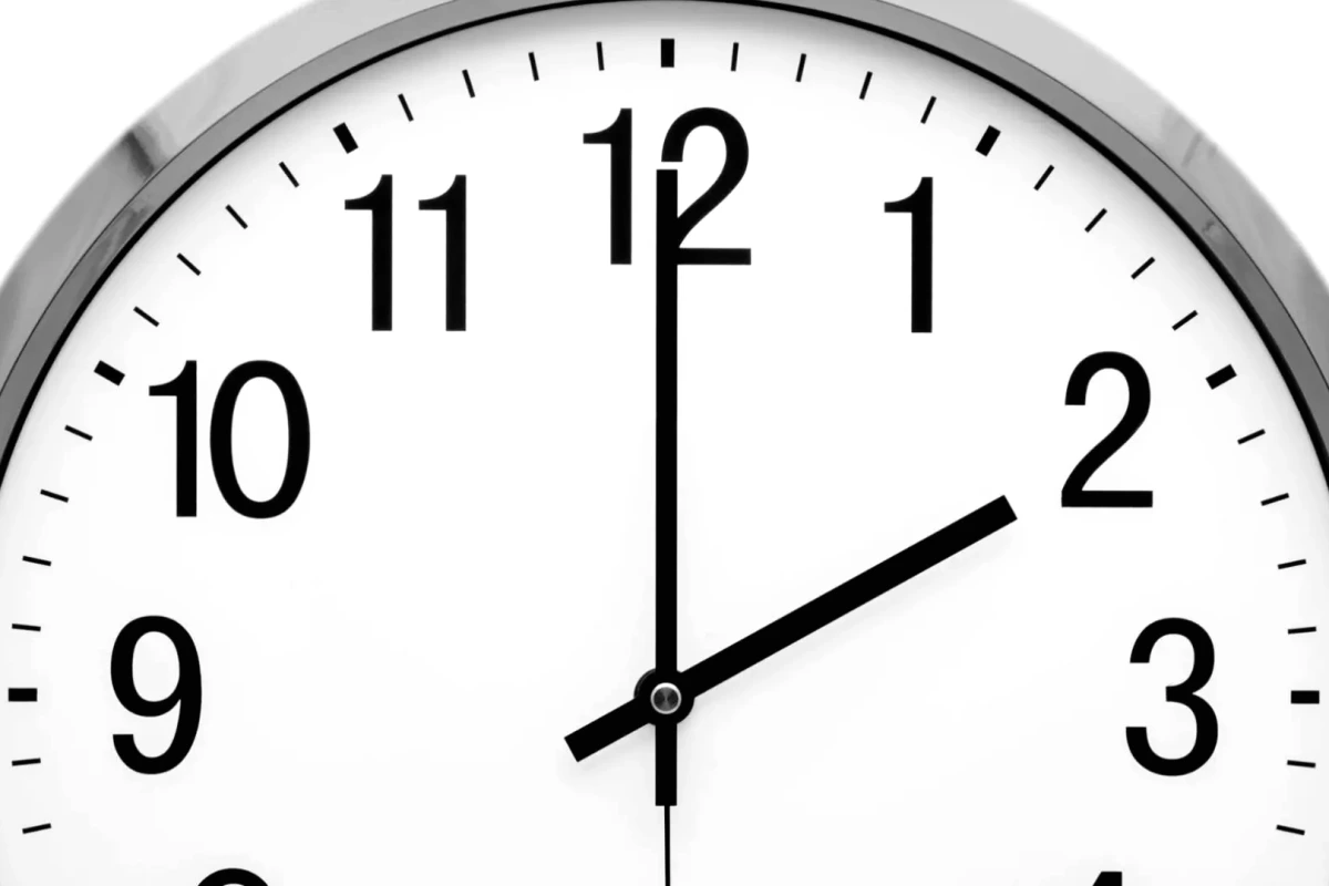 Horloge analogique sur fond de drapeau espagnol indiquant le changement d’heure d’été en Espagne 2026