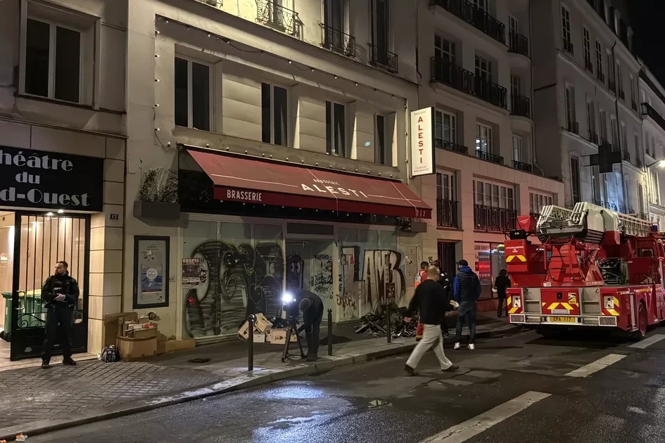 Immeuble du IXe à Paris en feu, pompiers et camions rouges intervenant, fumée dense au-dessus de la rue