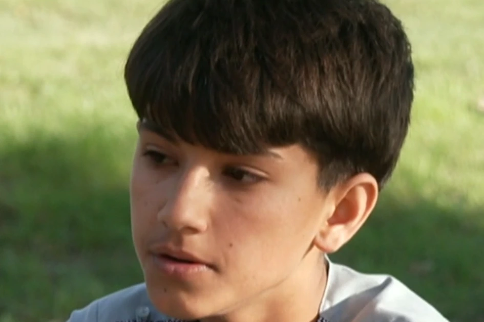 Le fils et le frère d’un Afghan mort en détention ICE posent devant un bâtiment, tenant des documents.