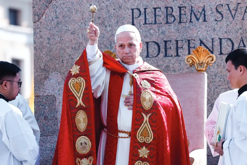 Le pape Léon XIV en tenue blanche salue la foule depuis un balcon du Vatican, main levée