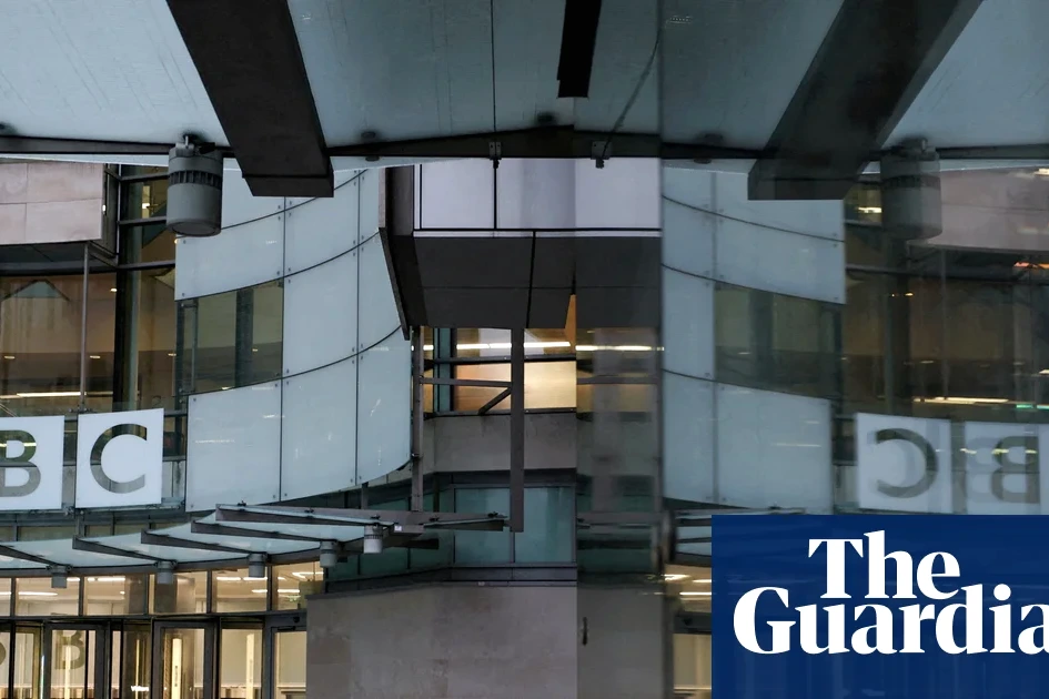 Logo de la BBC sur la façade d’un bâtiment, avec des drapeaux britanniques flottant à l’entrée
