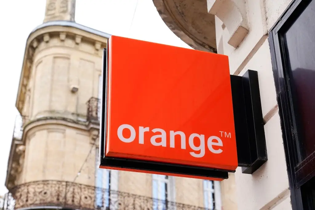 Logo Orange sur un smartphone affichant un appel entrant avec le vrai nom de l’appelant et anti-spam