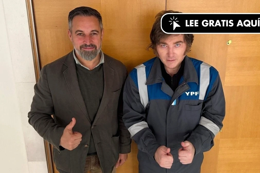 Milei en combinaison YPF rencontre Abascal à Madrid, serrant la main devant des drapeaux espagnols.