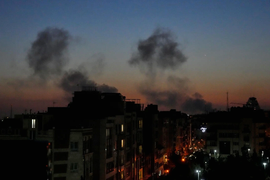 Panache de fumée au-dessus de Téhéran après des frappes israéliennes, immeubles en silhouette au crépuscule