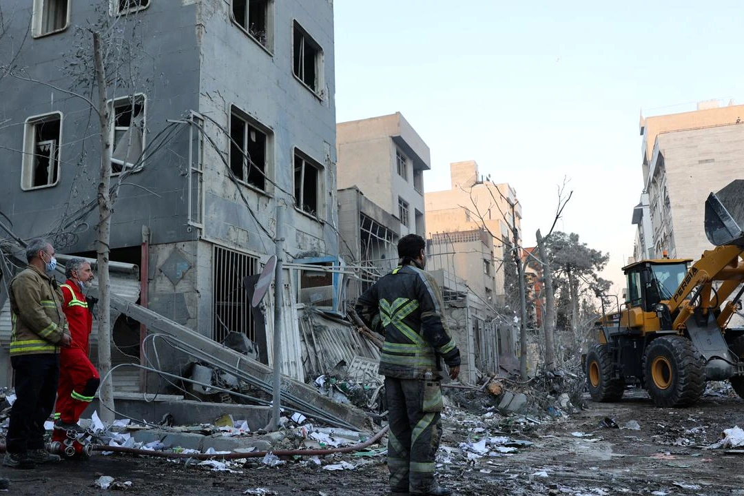 Panache de fumée au-dessus de Téhéran après une attaque, avec immeubles et ciel gris en arrière-plan