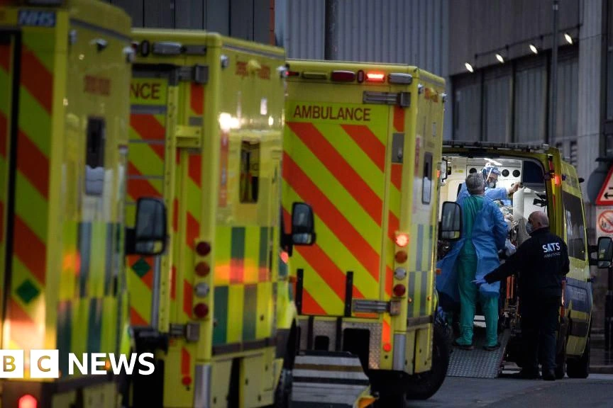 Personne lisant un rapport Covid sur écran, avec en arrière-plan une affiche « stay at home » sur une porte