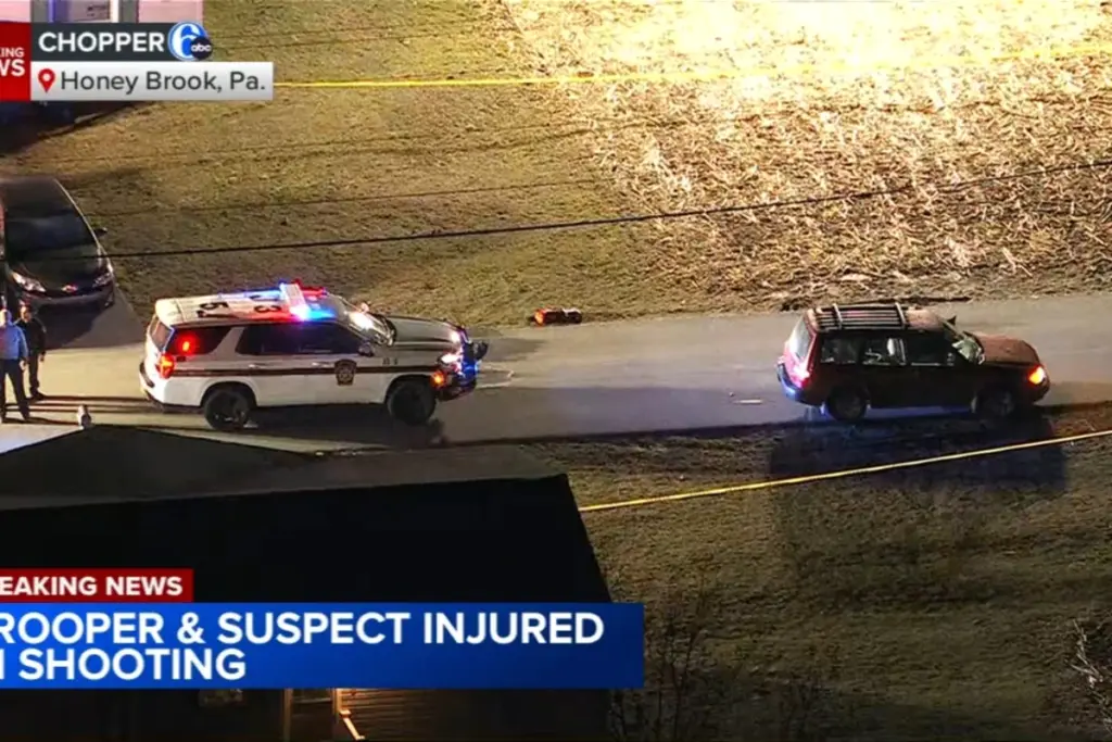 Policier de l’État de Pennsylvanie devant des véhicules de police à West Caln Township, de nuit