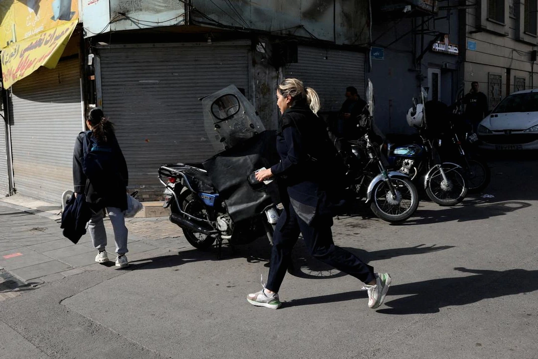 Portrait de l’ayatollah Ali Khamenei en arrière-plan, avec drapeaux iraniens et journalistes au premier plan