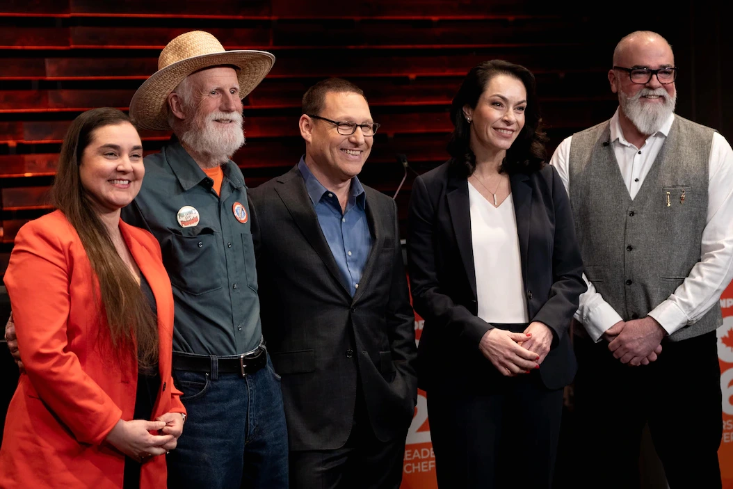 Portrait d’un chef du NPD devant un micro, avec le logo du parti en arrière-plan lors d’un point de presse
