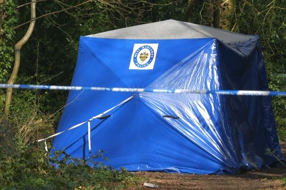 Poubelle et ruban de police dans une rue de Coventry, enquête après un homme retrouvé mort dedans