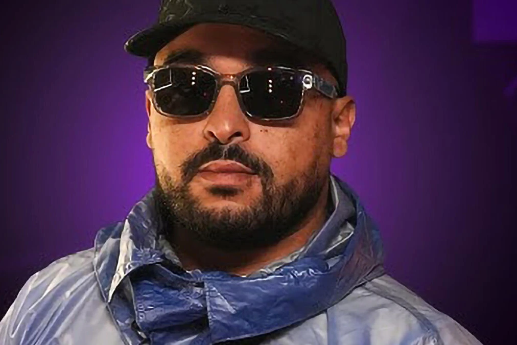 Rappeur menotté entouré de policiers, logo d’un label en arrière-plan, enquête « Opération Octopus » DZ Mafia