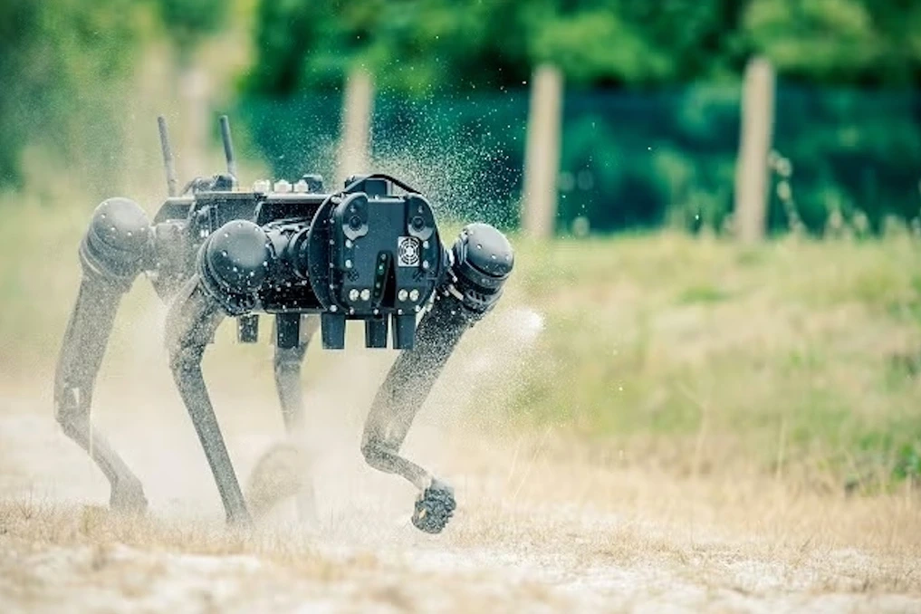 Robot-chien de patrouille dans un data center d’IA, marchant entre des rangées de serveurs éclairés