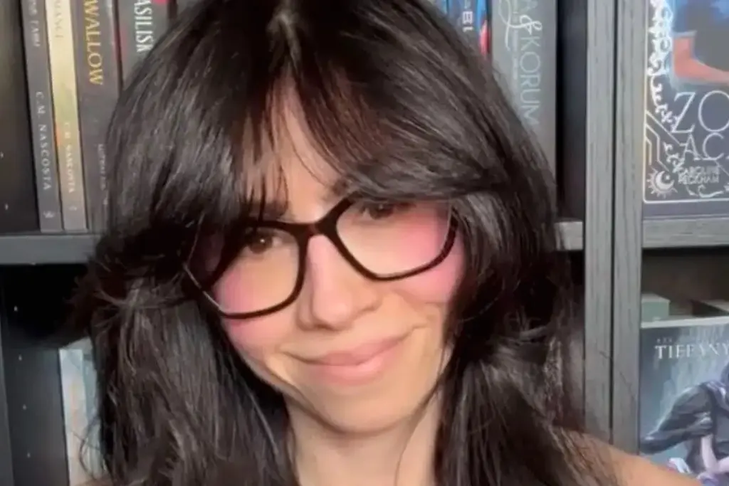 Sarah, 41 ans, assise sur un lit, regarde un écran affichant un visage d’IA dans une chambre sombre