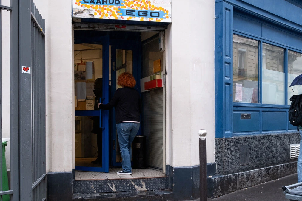 Scène de rue à Paris avec des associations et des passants près d’un point de crack, affiches d’alerte visibles