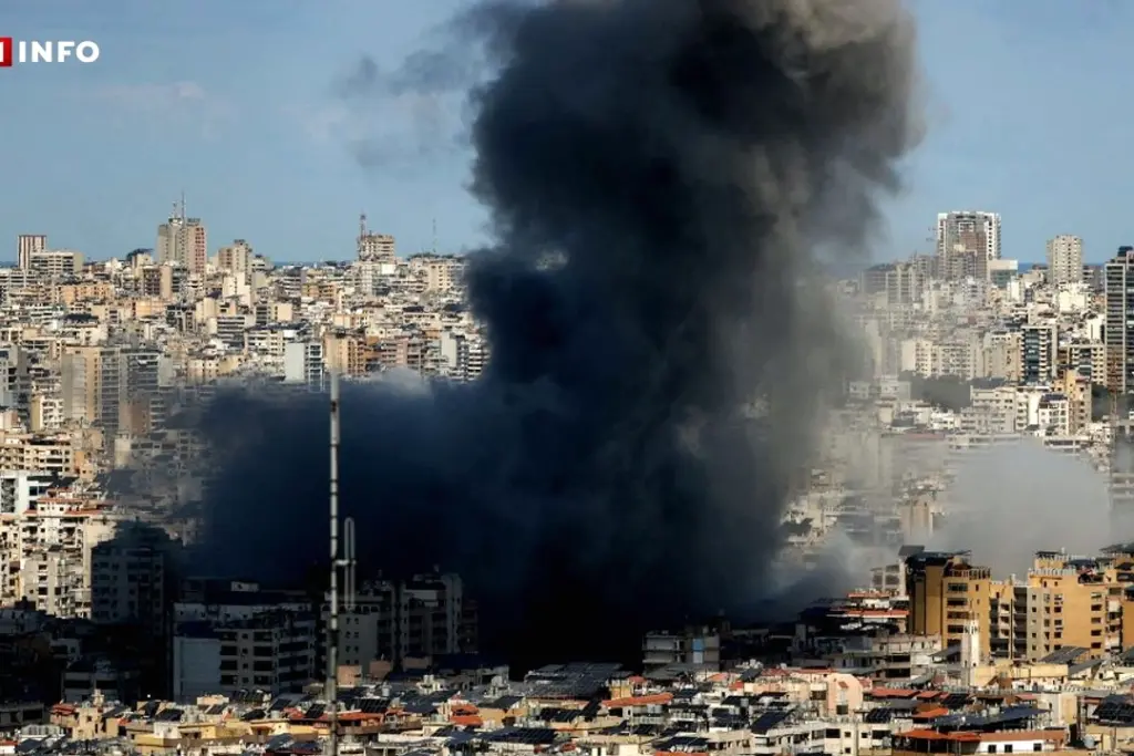 Secouristes au Liban transportant un blessé sur une civière, décombres et fumée en arrière-plan