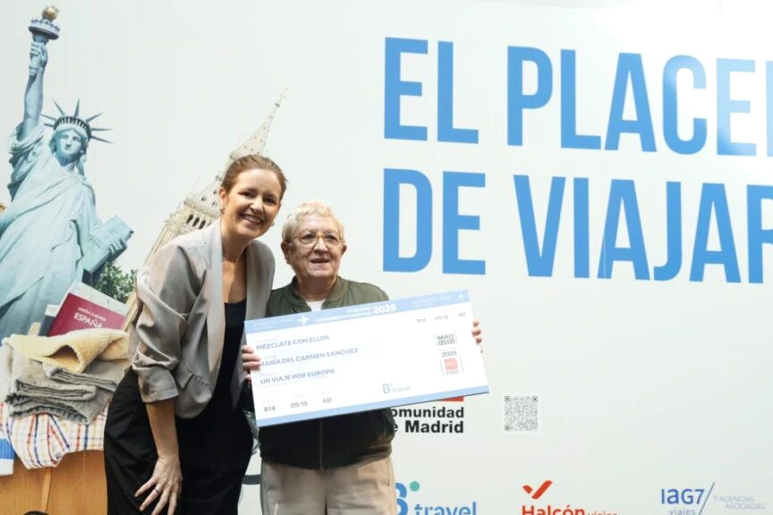 Seniors faisant la queue devant un comptoir de voyages de la Comunidad de Madrid, brochures à la main