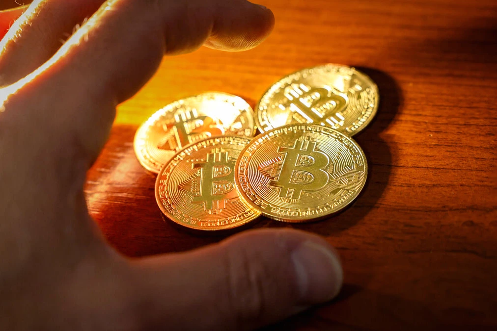 Smartphone affichant un portefeuille bitcoin et un montant, posé sur une table dans une maison au Chesnay-Rocquencourt