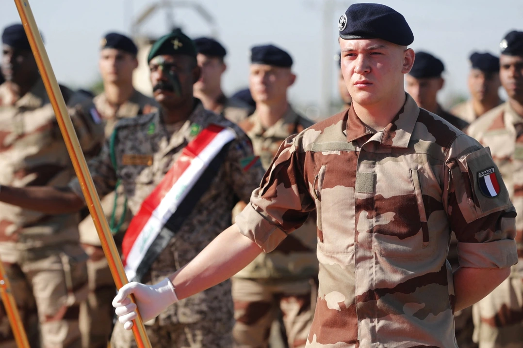 Soldats français en Irak près d’un véhicule militaire, inspectant des débris après une attaque de drones