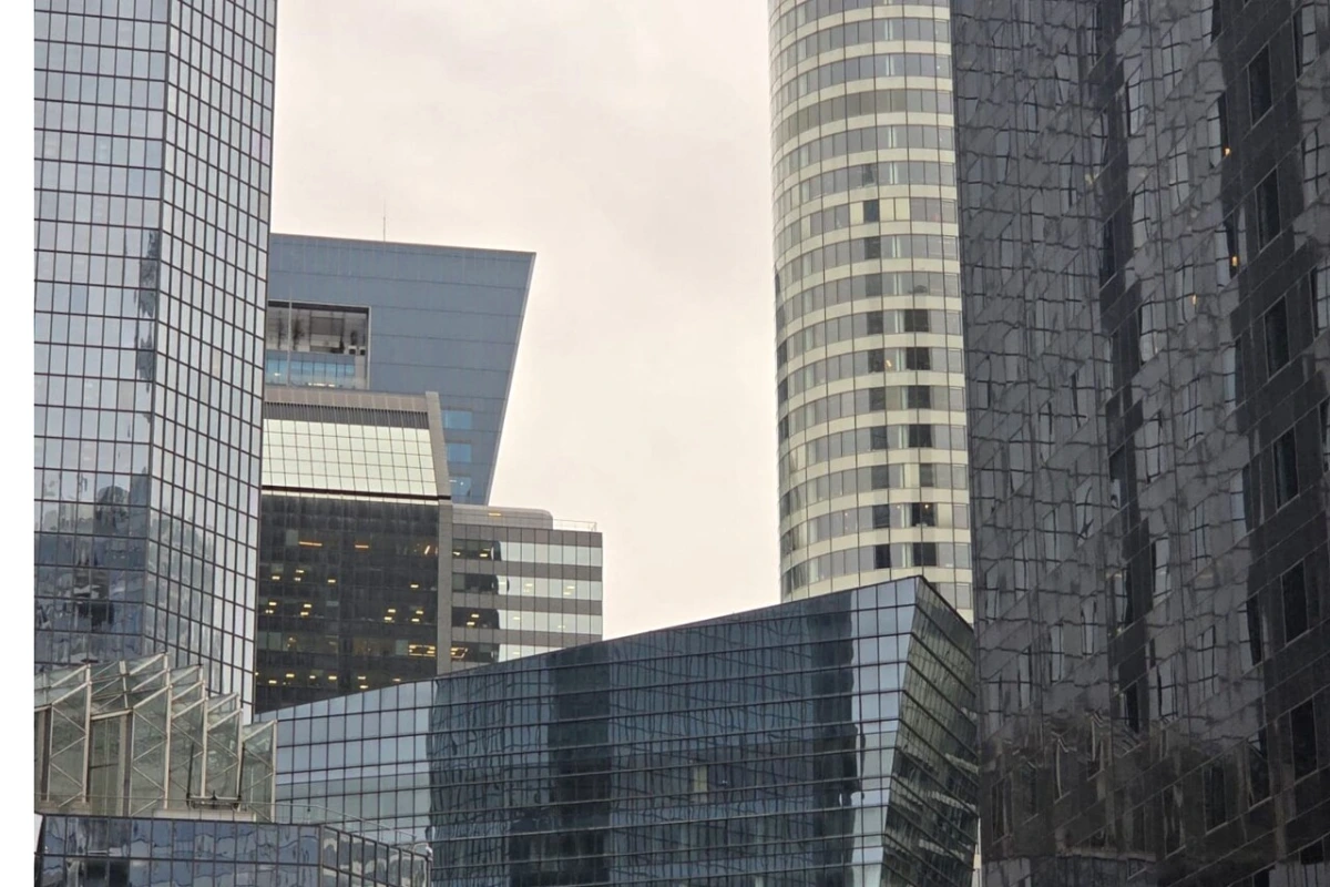 Tours de La Défense avec façades vitrées, passants sur l’esplanade et enseignes de luxe et beauté visibles
