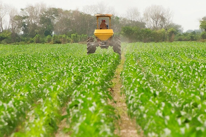 Un tracteur et un bateau de pêche près d’une pompe à gazole, illustrant les aides du gouvernement