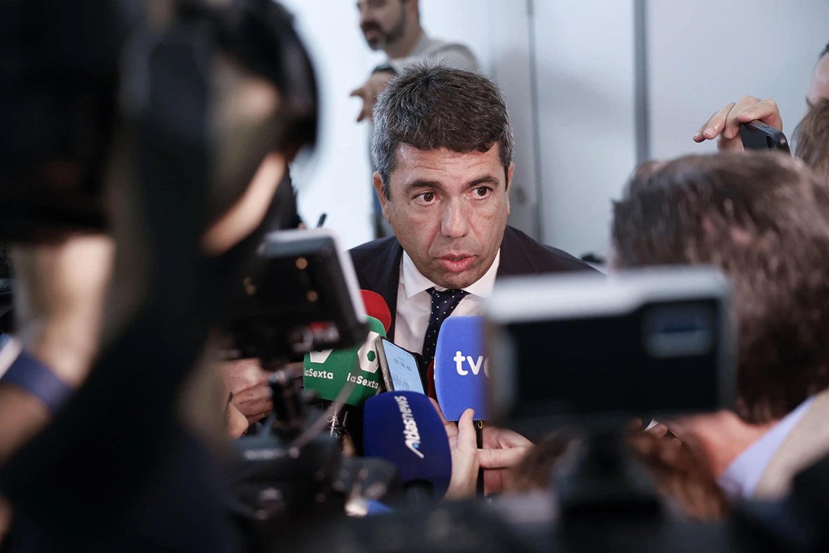 Victimes de la DANA rassemblées devant un bâtiment officiel, pancartes réclamant une enquête sur Mazón.