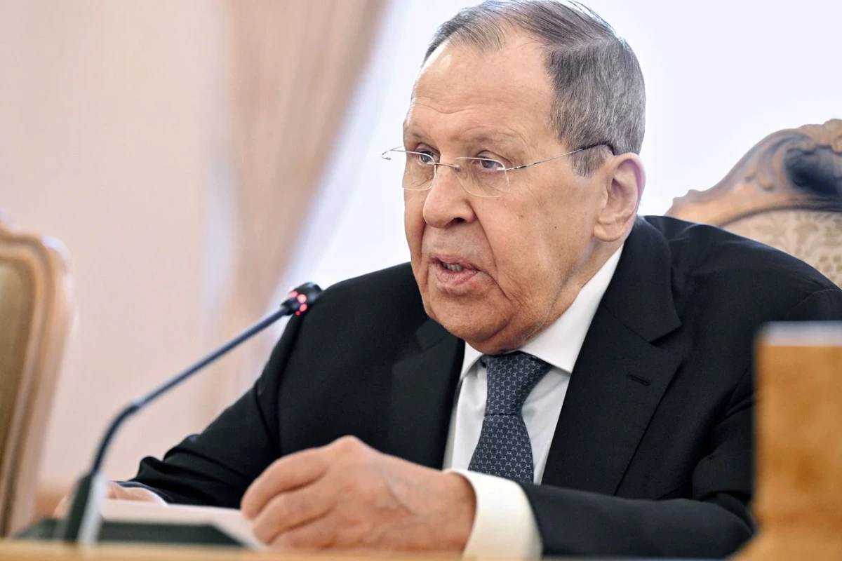 Volodymyr Zelensky en costume, devant des drapeaux, lors d’une visite officielle dans le Golfe