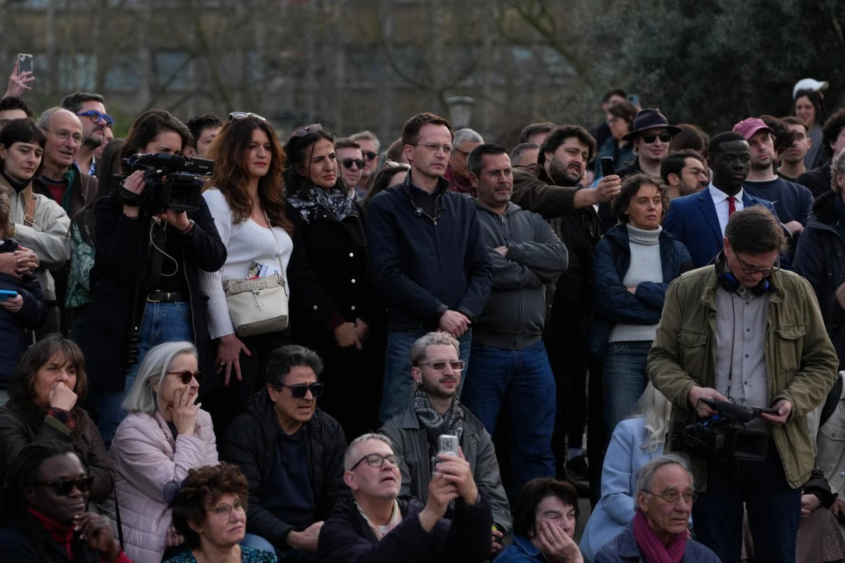 Vue de l’Hôtel de Ville de Paris avec drapeaux, façade éclairée et passants sur le parvis