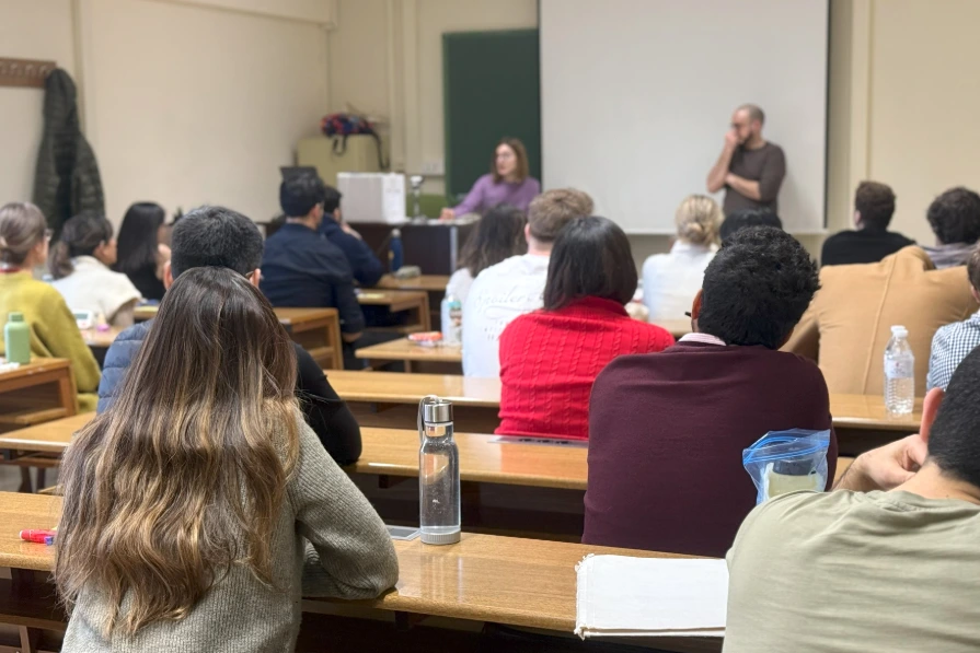 Adjudication MIR en présentiel le 4 mai, personnes assises en salle, documents et ordinateur sur table